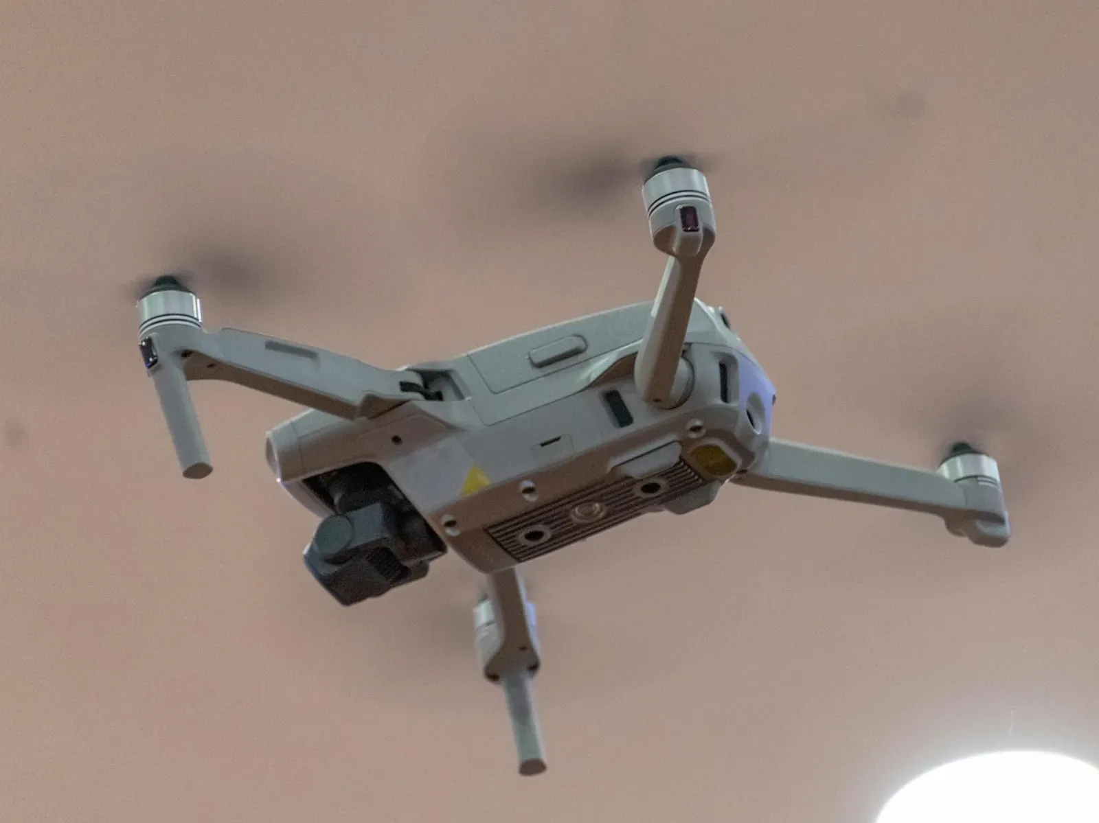 A traveller launching a compact recreational drone above a scenic mountain landscape at golden hour